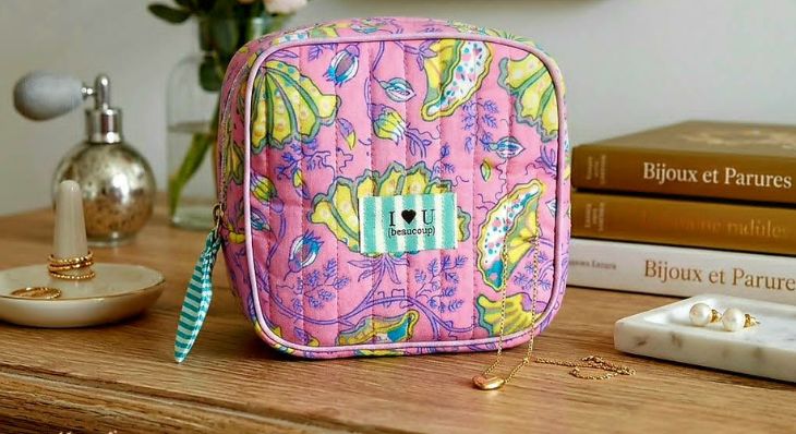 Petite trousse carrée matelassée rose avec motifs floraux faits main et étiquette brodée.