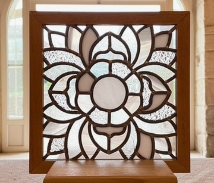 Vitrail de forme carrée avec un motif floral géométrique en verre texturé transparent, encadré de bois.