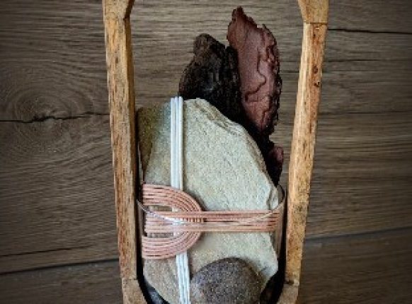 composition décorative de galets et pierre naturelles ornés de fil de cuir tressé dans un support en bois