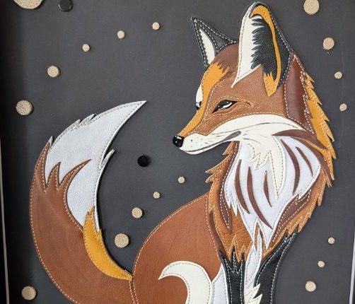 ableau encadré sur fond noir d'un renard majestueux assemblé avec des pièces de cuir cousues.
