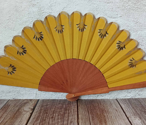 Éventail en coton jaune moutarde avec motifs Art Déco noirs et dorés imprimés en sérigraphie.